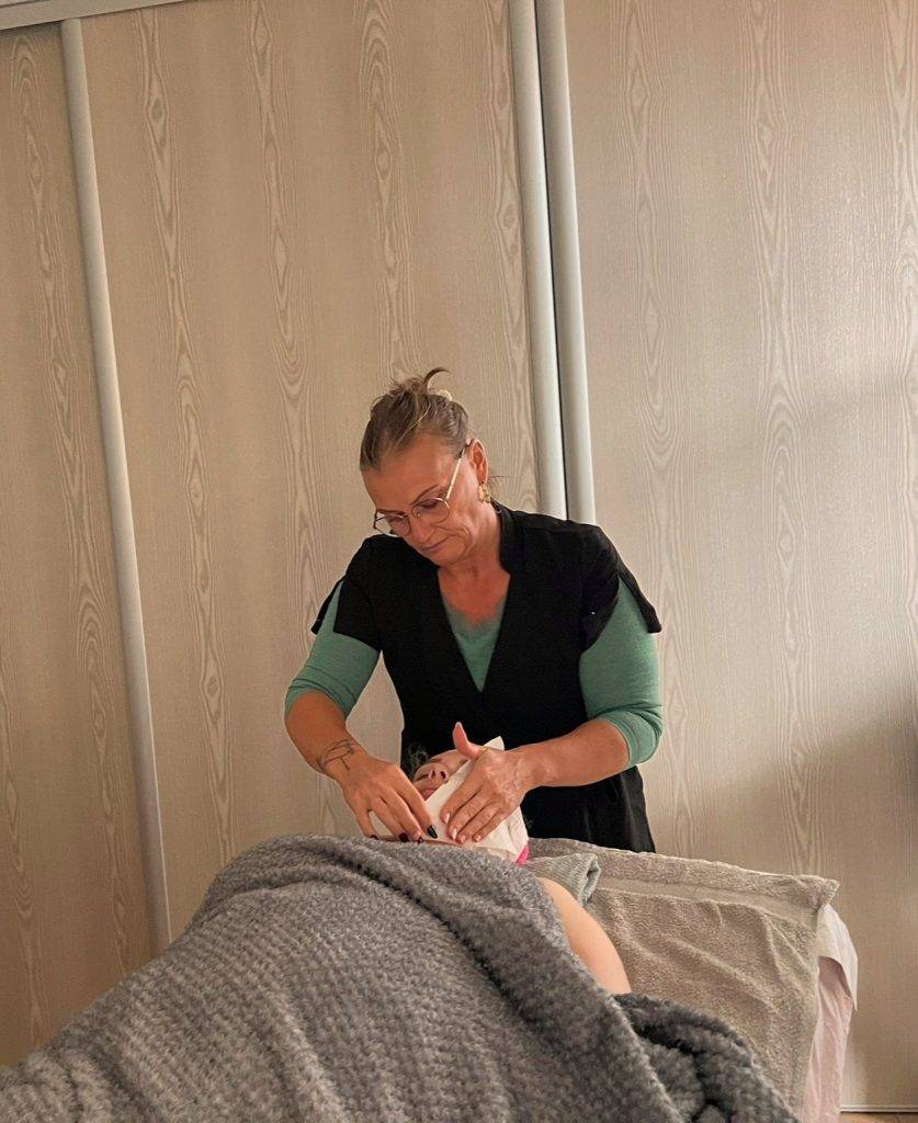 Directrice du salon entrain de pratiquer un soin du visage